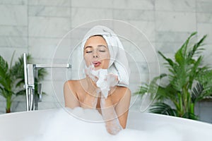 Girl taking bath with bubble foam at home.