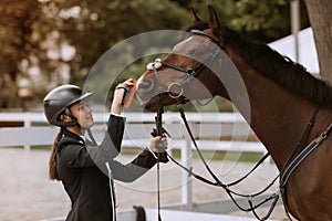 Girl taking care of her horse before horse riding. Equestrian sport