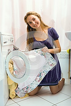 Girl taking clothers from washing machine