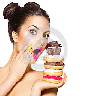 Girl taking colorful sweets and colorful donuts