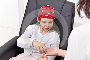 Girl taking electrodes from a doctor in a biofeedback therapy