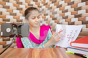 Girl taking online virtual class on mobile phone, busy in teaching at home during covid-19 or coronavirus pandemic