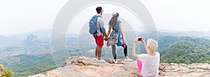 Girl Taking Photo Of Couple With Backpacks Posing Over Mountain Landscape On Cell Smart Phone Panorama, Trekking Young