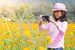 Girl taking photo mobile phones in flowers field