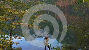 Girl taking a photo of mountain lake panorama