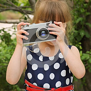 Girl taking photographs with retro camera