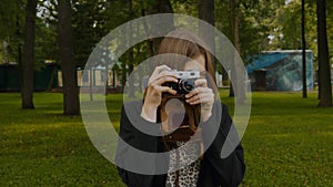 Girl taking photos by vintage camera.