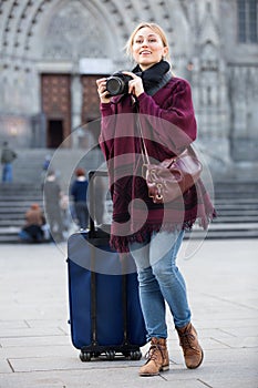 Girl taking picture with camera in the town