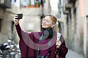 Girl taking picture with her phone in the town