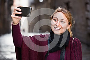 Girl taking picture with her phone in the town