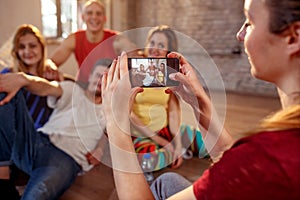 Girl taking picture of smiling dancer friends