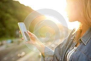 Girl taking pictures of a landscape, close-up of a phone in her