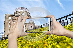 Girl taking pictures on mobile smart phone in atomic bomb,hiroshima,Japan