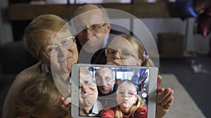 Girl taking selfie with grandparents on touchpad