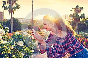 Girl taking smartphone photo to rose flower