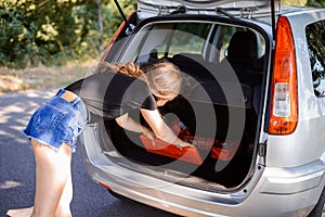 Girl taking something from baggage compartment