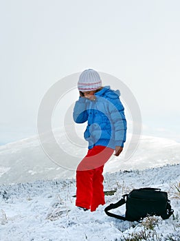 Girl talk by cellphone on mountain winter plateau