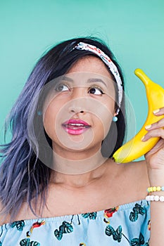 Girl talking with a banana. Yellow makeup. Fun