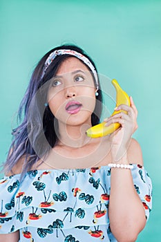 Girl talking with a banana. Yellow makeup. Fun