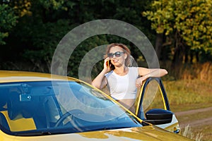 Girl is talking on phone by car