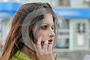 Girl is talking on the phone while walking around the city