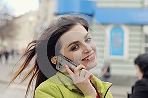 Girl is talking on the phone while walking around the city