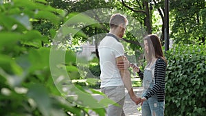 Girl talking and smiling guy use a mobile phone in the Park