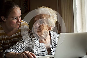 A girl teaches her grandmother how to use the computer.