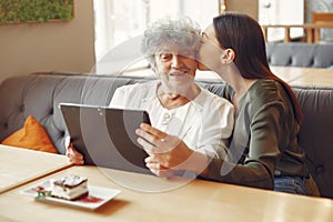 Girl teaching her grandmother how to use a tablet