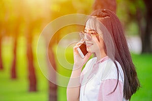 Girl teen on smartphone calling talking happy smile green outdor nature background