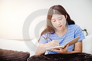 Girl teen taking short note writing to do list at bed when her wakeup in the morning photo