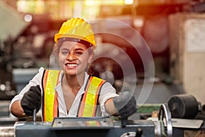 Girl teen worker with safety helmet happy smiling working labor in industry factory with steel machine photo