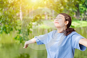 Girl teen young open arms fully breathe fresh clean ozone air in green outdoor park