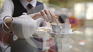 Girl teenage stir the sugar a teaspoon in a Cup of tea in the school cafeteria. Close-up of girl stir the sugar in a Cup