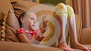 Girl teenager on couch and surfing internet to mobile phone in room, low angle