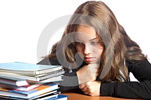 The girl-teenager looks at pile of books