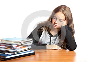 The girl-teenager looks at pile of books