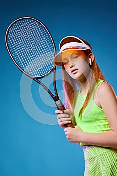 girl teenager with racket in sporswear and hat