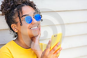 Girl teenager teen female young African American woman wearing sunglasses using cell phone