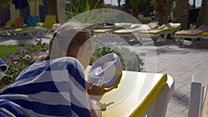 Girl teenager typing message on mobile phone during sunbath on chaise longue