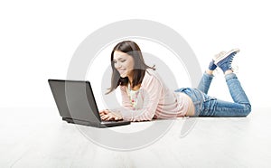 Girl teenager using wireless laptop. Woman Typing in computer lying on white floor.