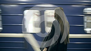 Girl teenager waiting for the subway train waits and comes aboard