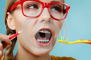 Girl with teeth braces using interdental and traditional brush