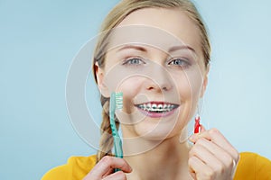 Girl with teeth braces using interdental and traditional brush