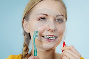 Girl with teeth braces using interdental and traditional brush