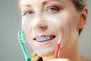 Girl with teeth braces using interdental and traditional brush