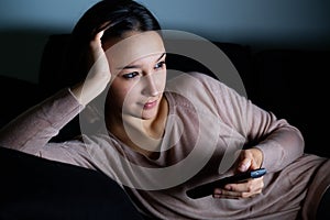 Girl with television remote watching a movie