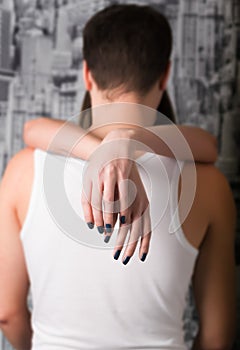 Girl tenderly embraces the man's neck, girl's hands only seen