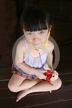 Girl testing stethoscope on toy dog