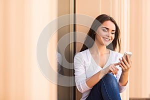 Girl text message on the phone on the window of street coffee shop